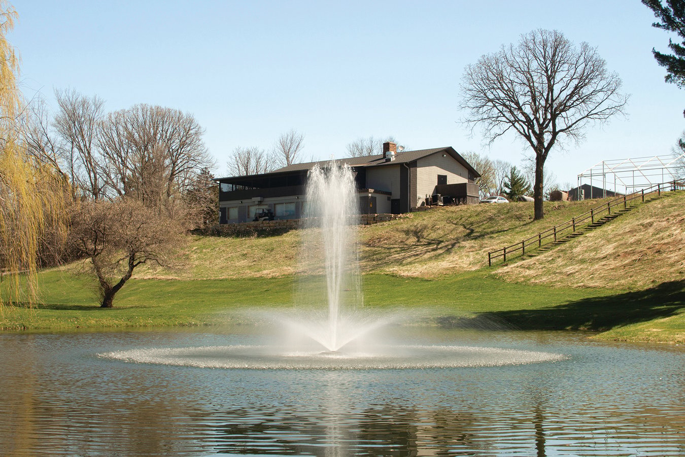 fountain in pond with house